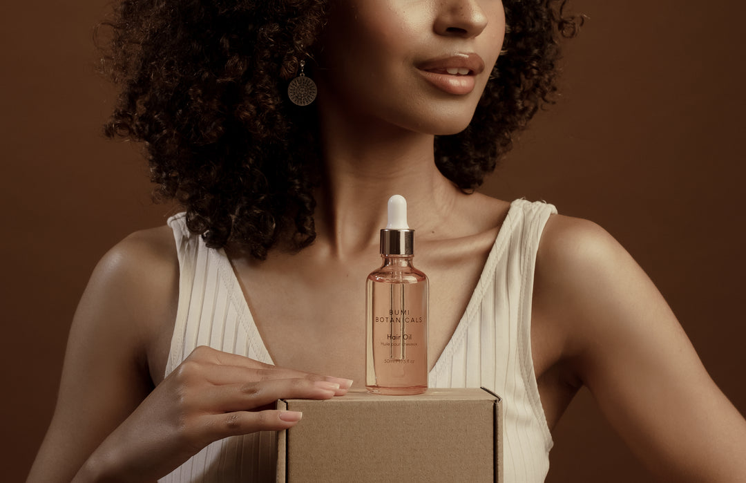 model showcasing bumi hair oil product
