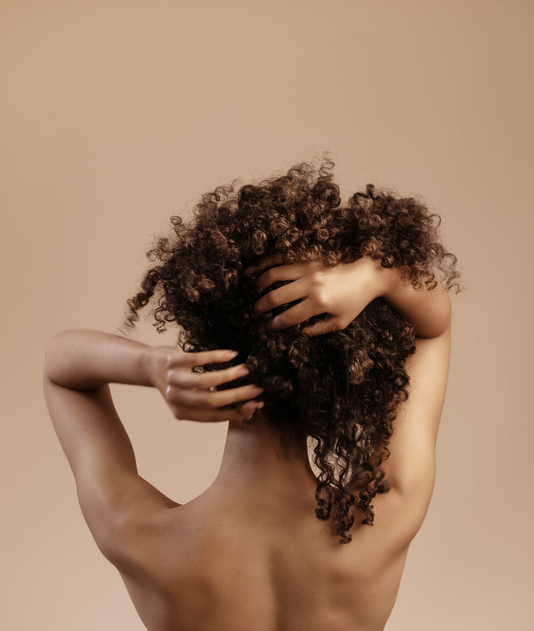 beautiful black and polish woman gently massaging her scalp and curly hair